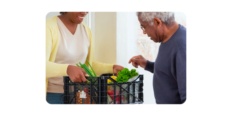 Women receiving Woolworths groceries from a delivery driver