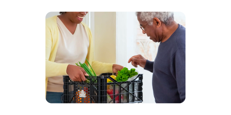 Women receiving Woolworths groceries from a delivery driver